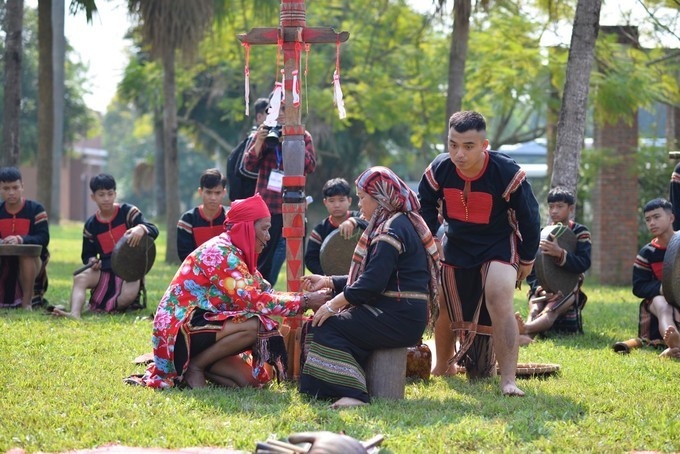 The shaman gives a bronze bracelet to Y Hai Kbuor as a symbol of sustainability, development, good life, and good health.