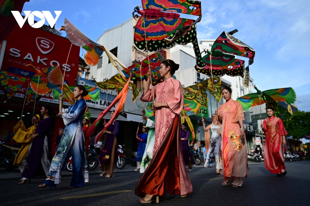 Local artists join a parade of Hue royal kites.