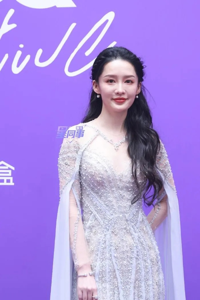 Diễn viên Lý Thấm lựa chọn váy dạ hội đính kim tuyến cầu kỳ thay vì trang phục truyền thống được hé lộ trước thềm sự kiện. Tạo hình được cho là không mấy ăn khớp chủ đề đêm hội.