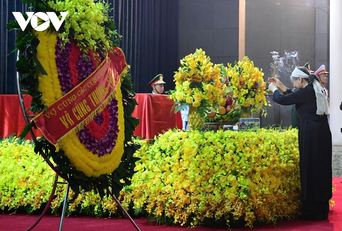 Ngo Thi Man, spouse of the Party General Secretary, offers incense to her husband in front of his coffin at the National Funeral House in Hanoi.