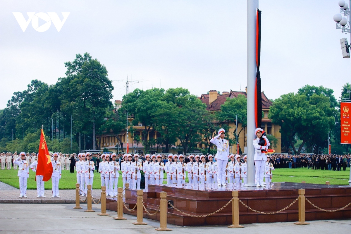 The Command of President Ho Chi Minh Mausoleum performs a sacred ceremony of hanging funeral ribbons on the National Flag at Ba Dinh Square on July 25.