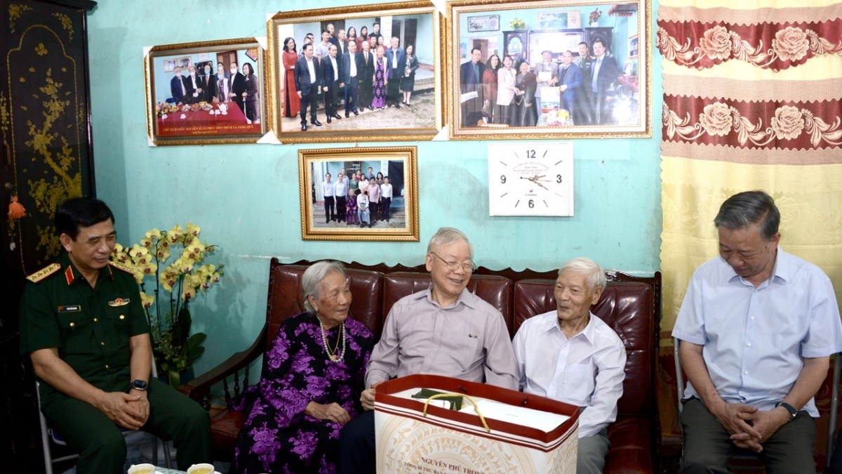 General Secretary Nguyen Phu Trong inquires into the health of Nguyen Xuan Khoat, a veteran revolutionary in Lang Son city.