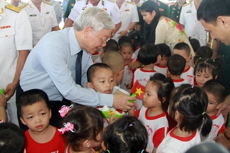 The Party General Secretary presents candy to children at Truong Sa Kindergarten during his working visit to the Fourth Regional Command of the Vietnam People’s Navy in 2016.