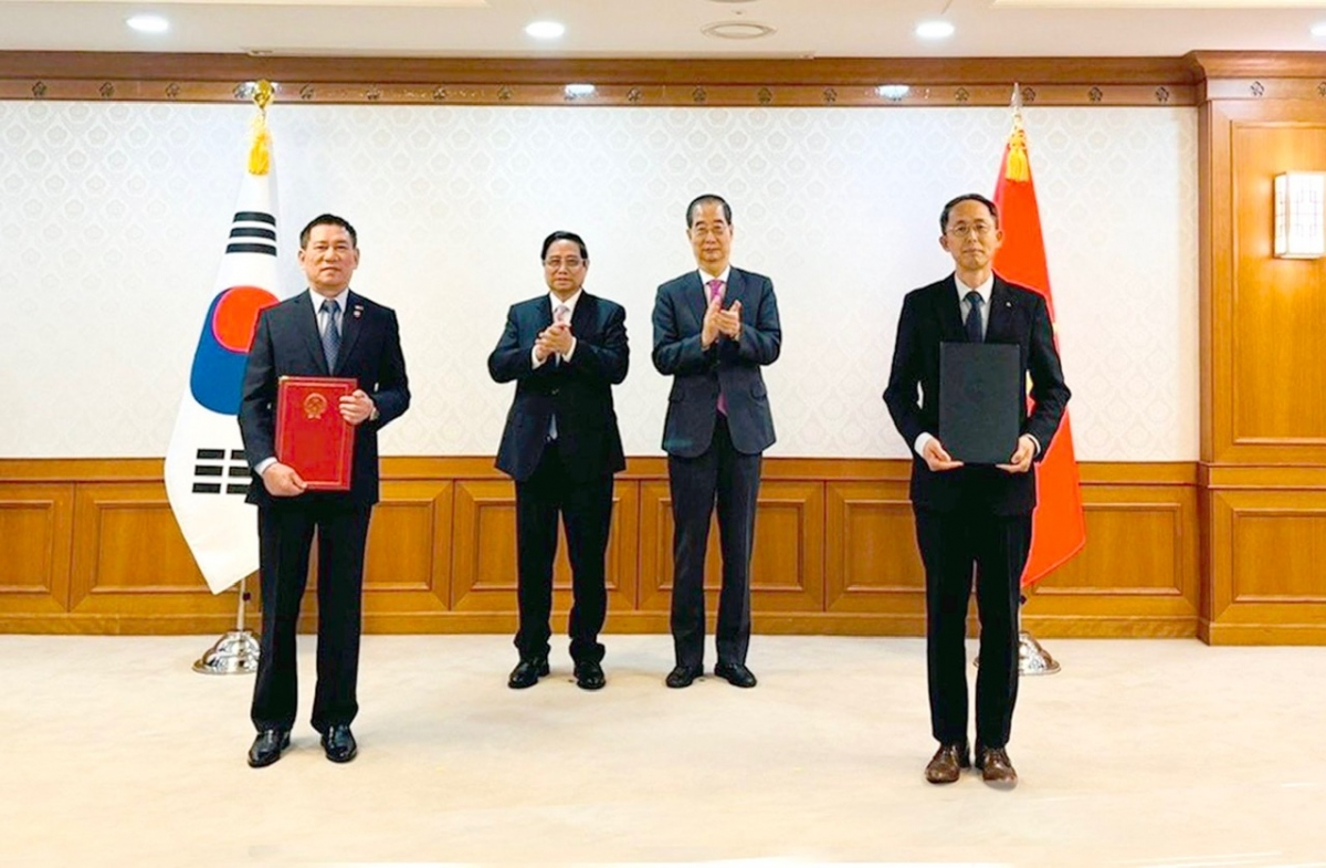 Bộ trưởng Bộ Tài chính Hồ Đức Phớc và Giám đốc điều hành cấp cao của Ngân hàng Xuất nhập khẩu Hàn Quốc - ông Hwang Ki-yeon trao đổi văn kiện.