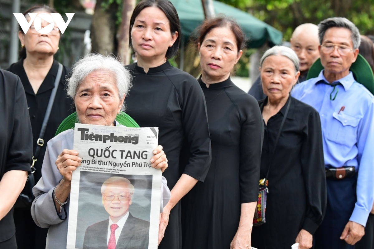 Holding tight a newspaper with information about the State funeral, Le Thi Nhung, 80, says she left her house at 6:30 a.m. and sat in the flower garden waiting for the time to say her last goodbye to the Party leader.