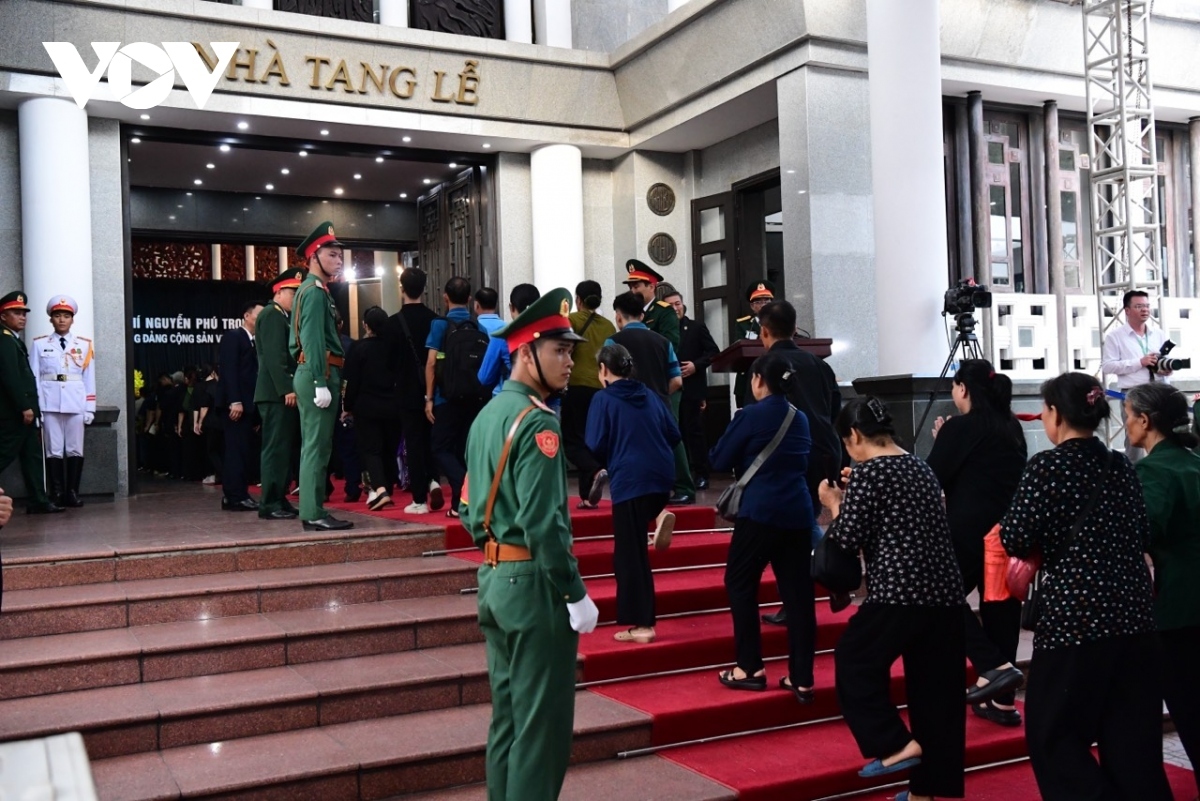 People quietly enter the funeral house to pay their respects to the top leader.