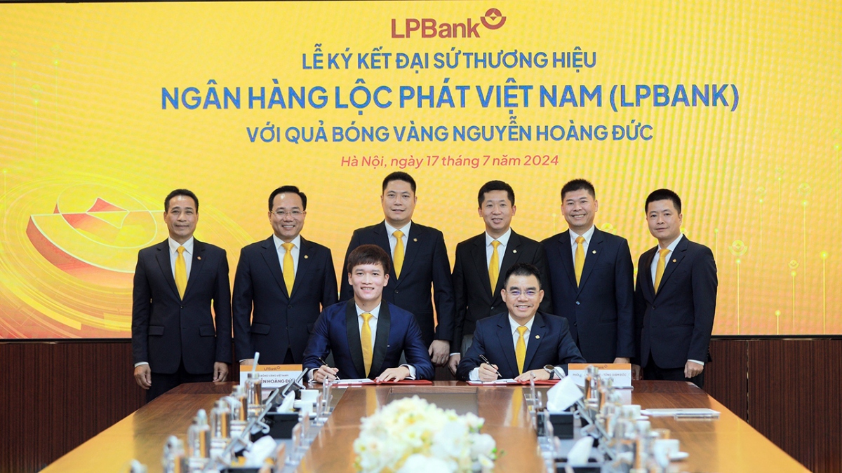 Quả bóng vàng Hoàng Đức (trái), ông Hồ Nam Tiến – Tổng Giám đốc LPBank (phải) ký Thỏa thuận Đại sứ thương hiệu dưới sự chứng kiến của Ban lãnh đạo Ngân hàng Lộc Phát Việt Nam