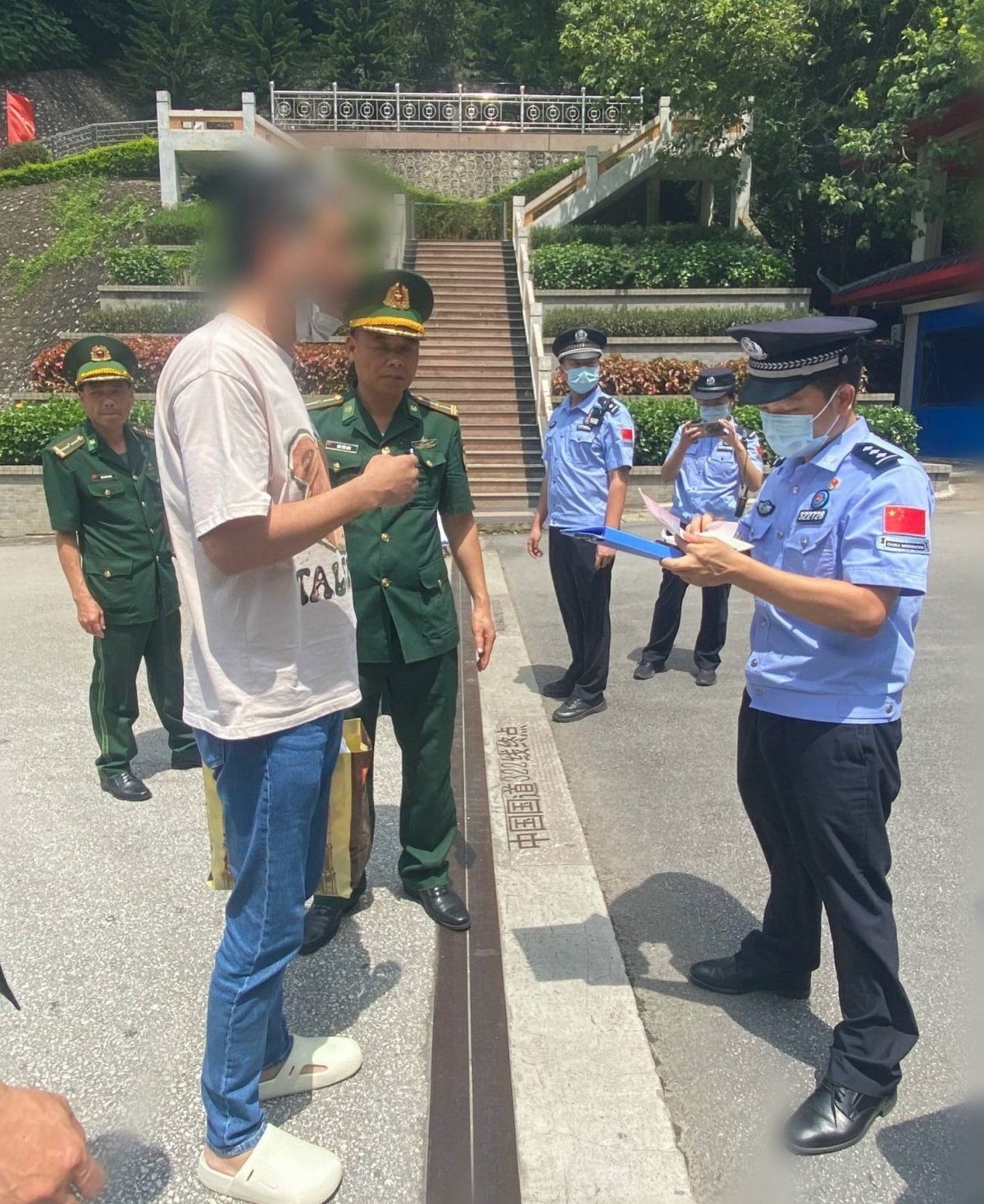 Cơ quan chức năng Việt Nam chuyển giao đối tượng Fang Liang (áo trắng) cho phía Trung Quốc.