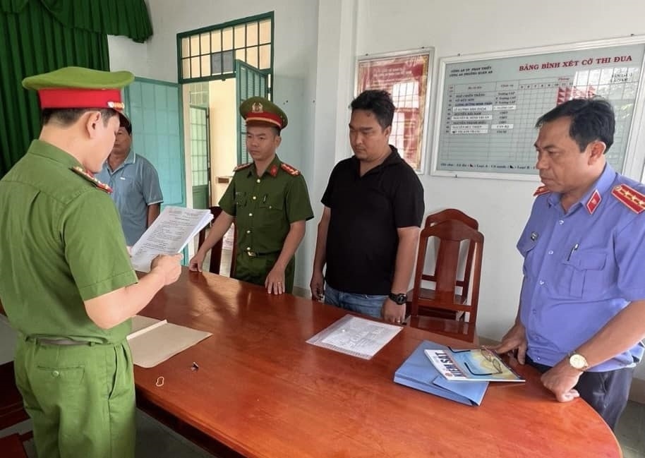 Lực lượng chức năng đọc quyết định khởi tố bị can đối với Phạm Quốc Huy. (Ảnh: CANT)