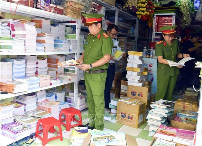 Lực lượng Cảnh sát kinh tế (Công an tỉnh Quảng Bình) kiểm tra phát hiện hai cơ sở buôn bán sách, vở lậu trên địa bàn. (Ảnh: TTXVN)