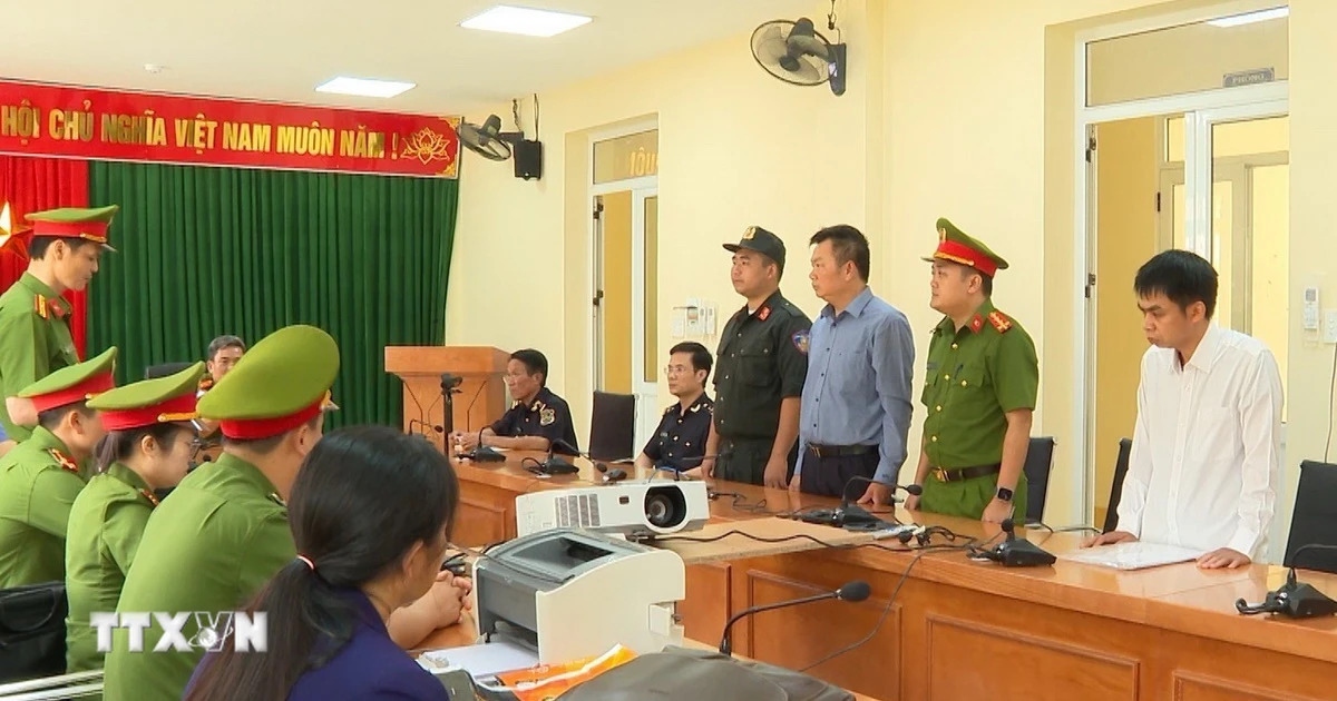 Lực lượng chức năng đọc lệnh bắt 2 đối tượng Nguyễn Tứ và Đinh Đức Minh. (Ảnh: TTXVN phát)