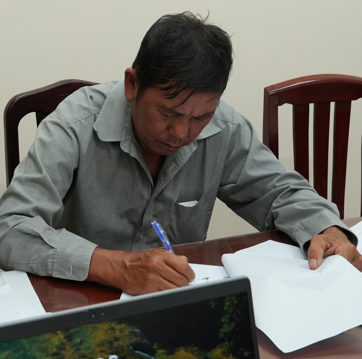Đối tượng Vương Văn Hồng Nam ký vào biên bản phạm tội. Ảnh: Thế Phong