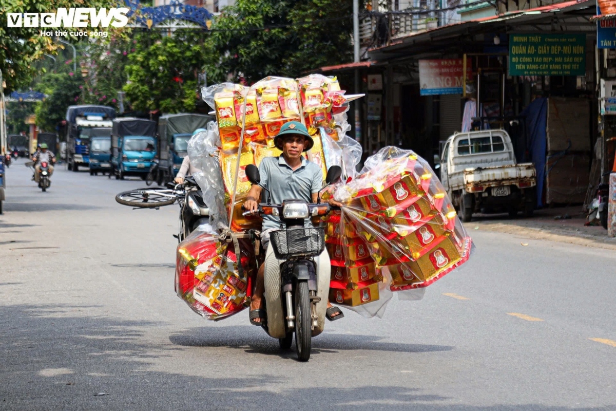 Người dân tất bật vận chuyển vàng mã đến các cửa hàng cho thương lái thu mua.