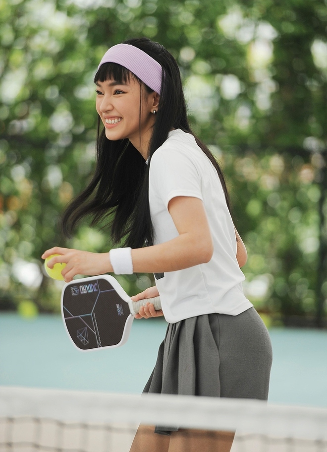 Châu Bùi tươi tắn khi tập luyện pickleball. Là một fashionista nên cả lúc tập thể thao, Châu Bùi cũng diện những bộ đồ vô cùng cá tính. Cô lựa chọn áo phông thể thao cùng chân váy, kết hợp với băng trán thể thao màu tím.