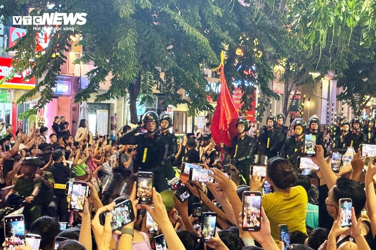Crowds of people throng along the walking street watching the cavalry march