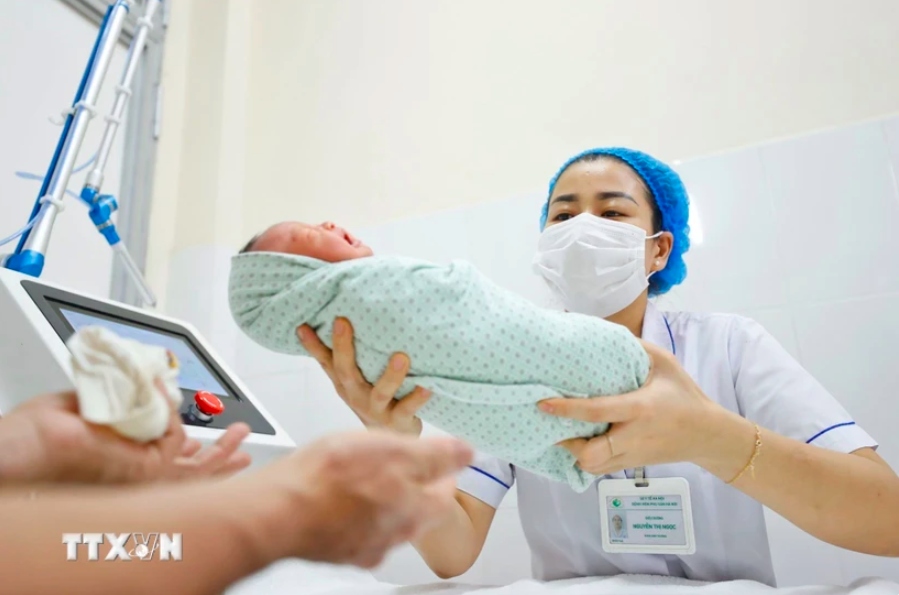 Nhân viên y tế chăm sóc cho trẻ sơ sinh (Ảnh: Minh Quyết/TTXVN)