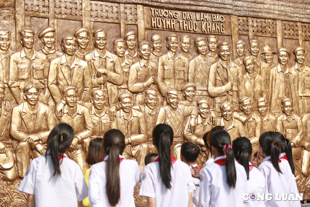 Học sinh sau chăm chú lắng nghe lịch sử về ngôi trường dạy làm báo Huỳnh Thúc Kháng.