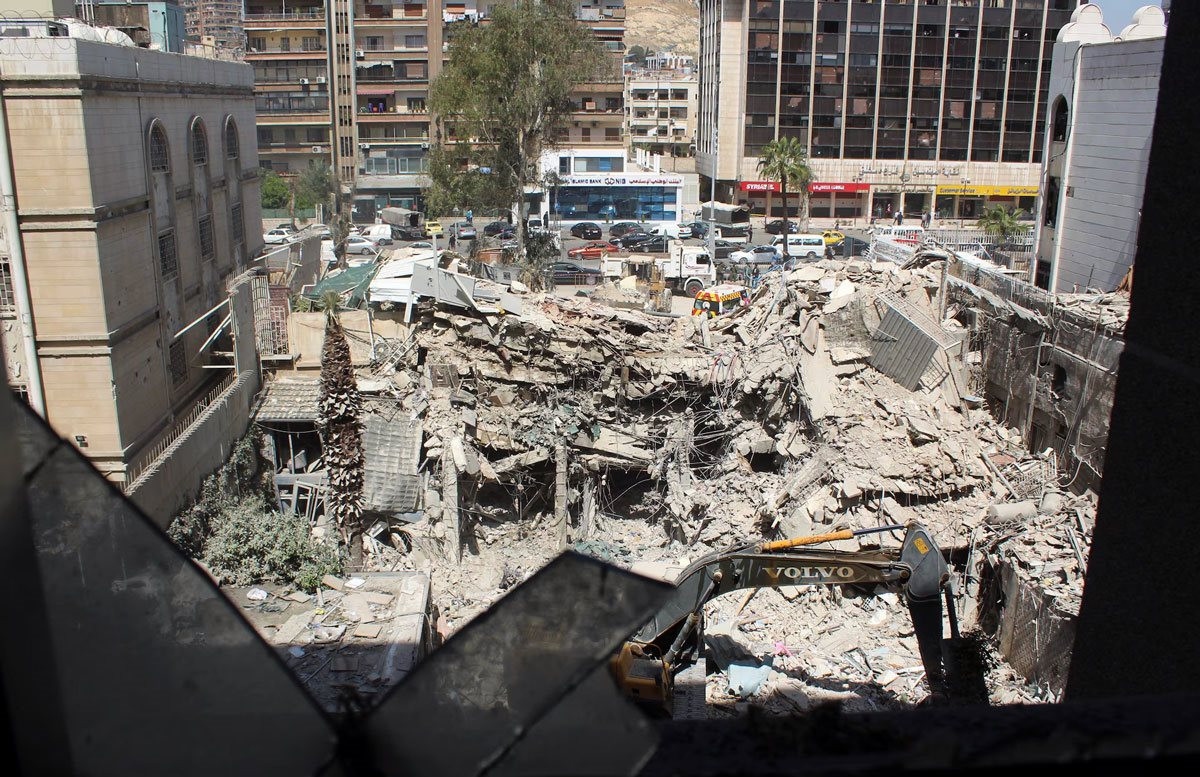 Máy xúc dọn dẹp đống đổ nát tại Lãnh sự quán Iran ở thủ đô Damascus (Syria) sau cuộc không kích. (Ảnh: Reuters)