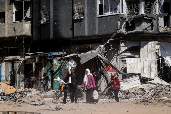 Người dân Palestine mang đồ đạc sơ tán khỏi khu vực đổ nát vì giao tranh ở Khan Younis, Dải Gaza ngày 7/4. Ảnh: AFP