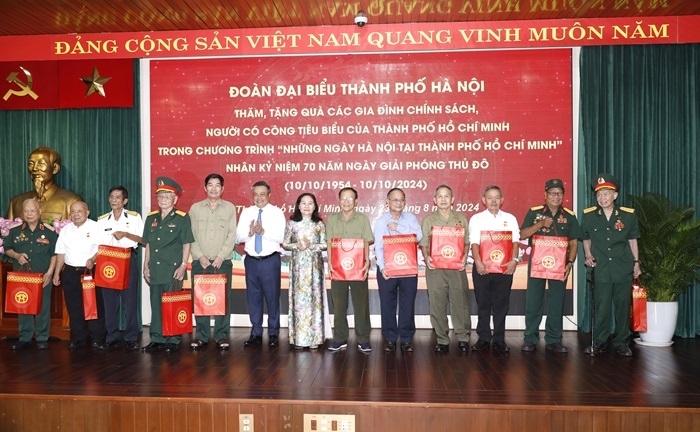 Đại biểu lãnh đạo thành phố Hà Nội và Thành phố Hồ Chí Minh tặng quà và chụp ảnh lưu niệm cùng các gia đình chính sách, người có công