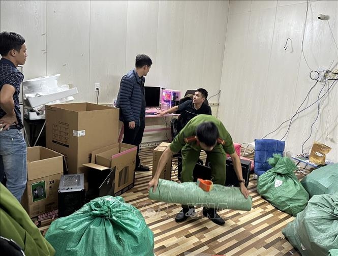 Lực lượng Công an thu giữ tang vật. (Ảnh: TTXVN phát)
