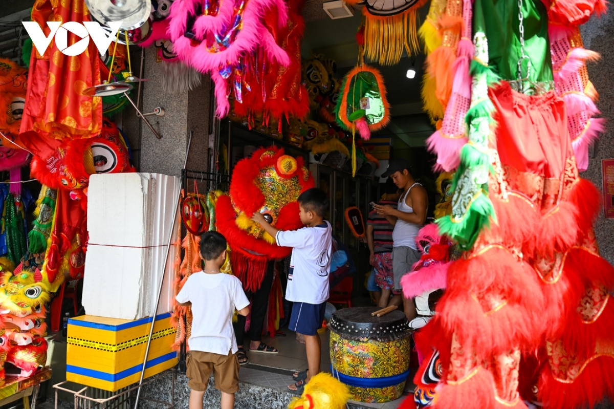 Many children are eager to try on a lion head at kiosks.