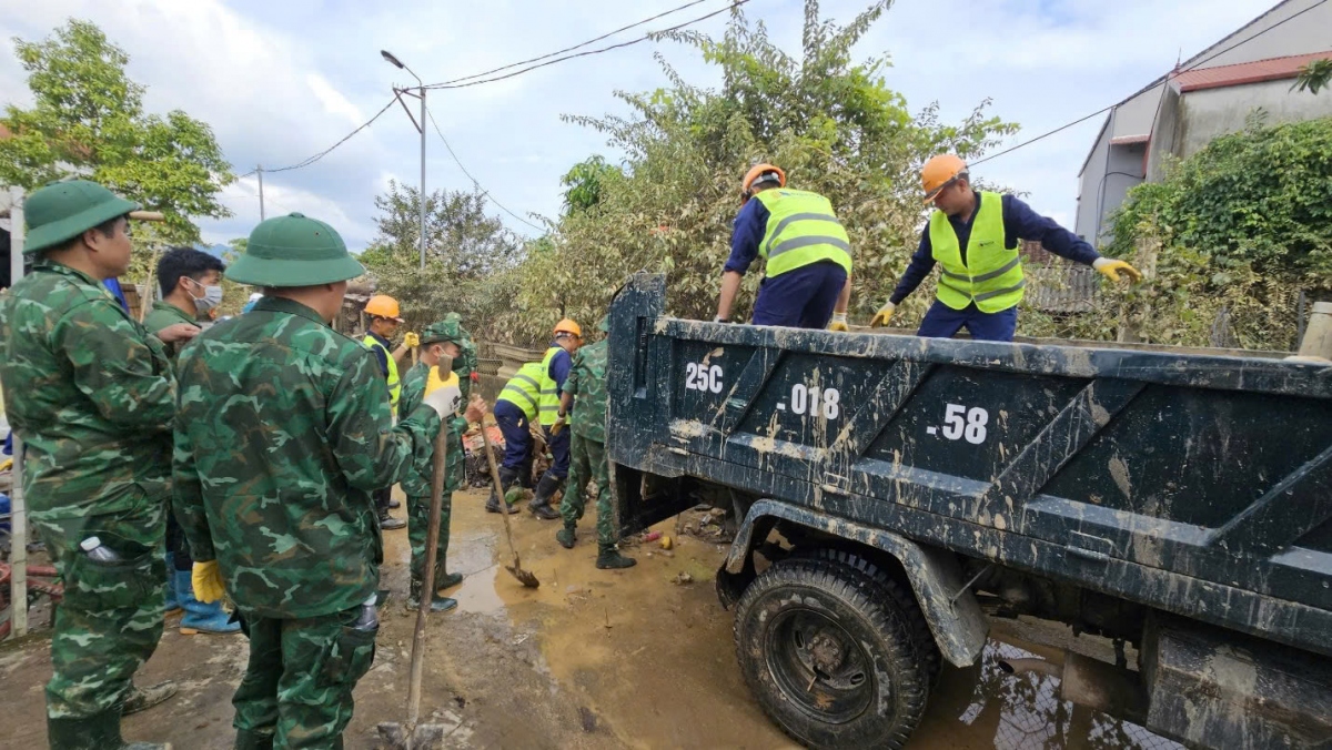 Các lực lượng chức năng sắn tay dọn dẹp giúp người dân sau bão số 3.