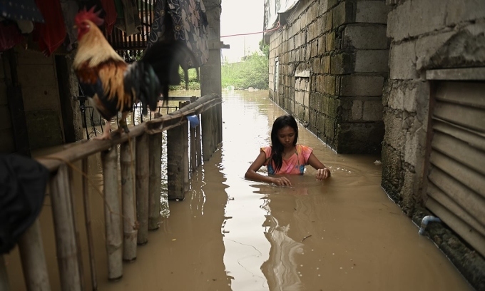 Người phụ nữ lội qua con hẻm ngập nước ở khu vực phía bắc Manila, Philippines ngày 4/9. Ảnh: Reuters