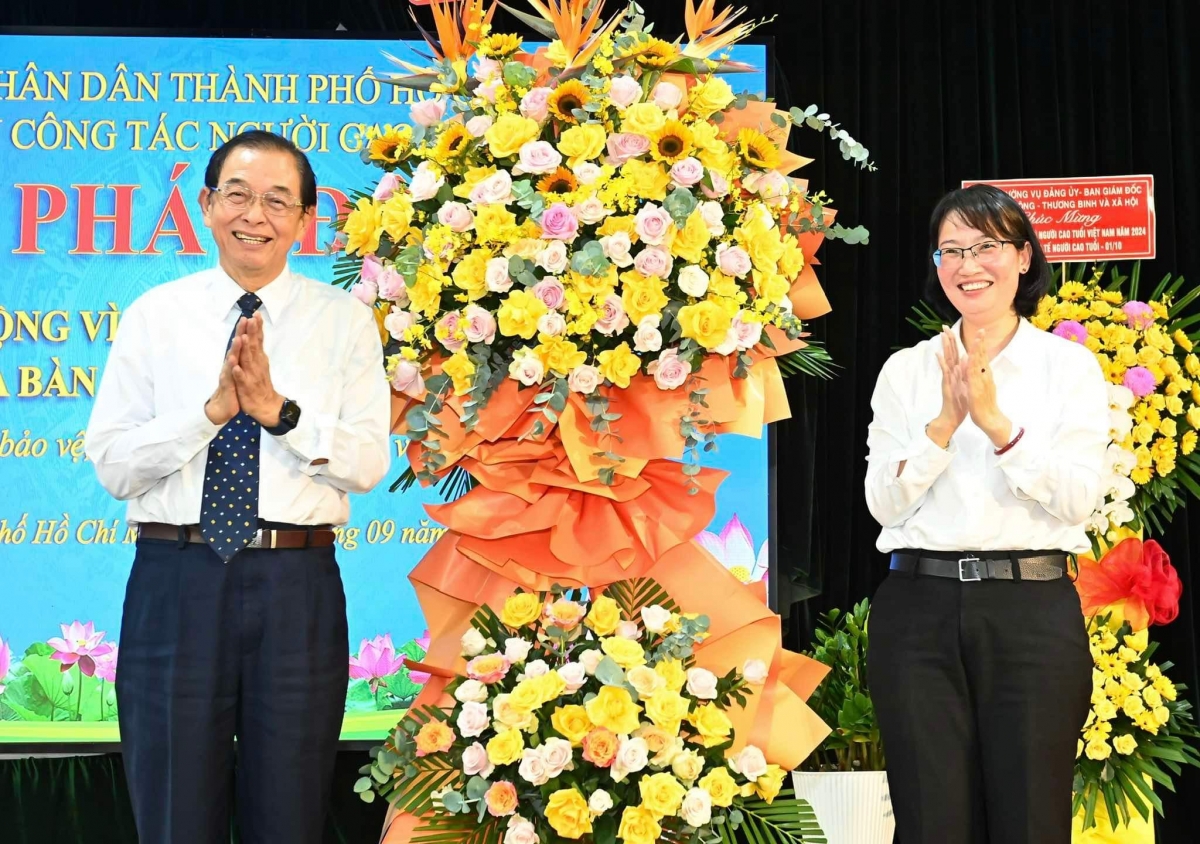 Lãnh đạo UBND TP.HCM tặng hoa cho Ban đại diện Hội NCT TP tại lễ phát động (ảnh: M.N)