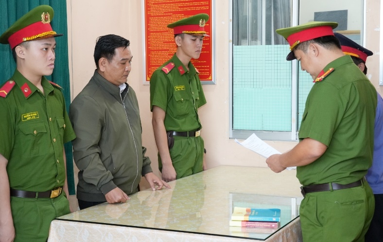 Cơ quan Cảnh sát điều tra tống đạt các quyết định tố tụng đối với bị can Lâm Sĩ Tiếng (áo khoác xám). (Ảnh: Thế Phong).