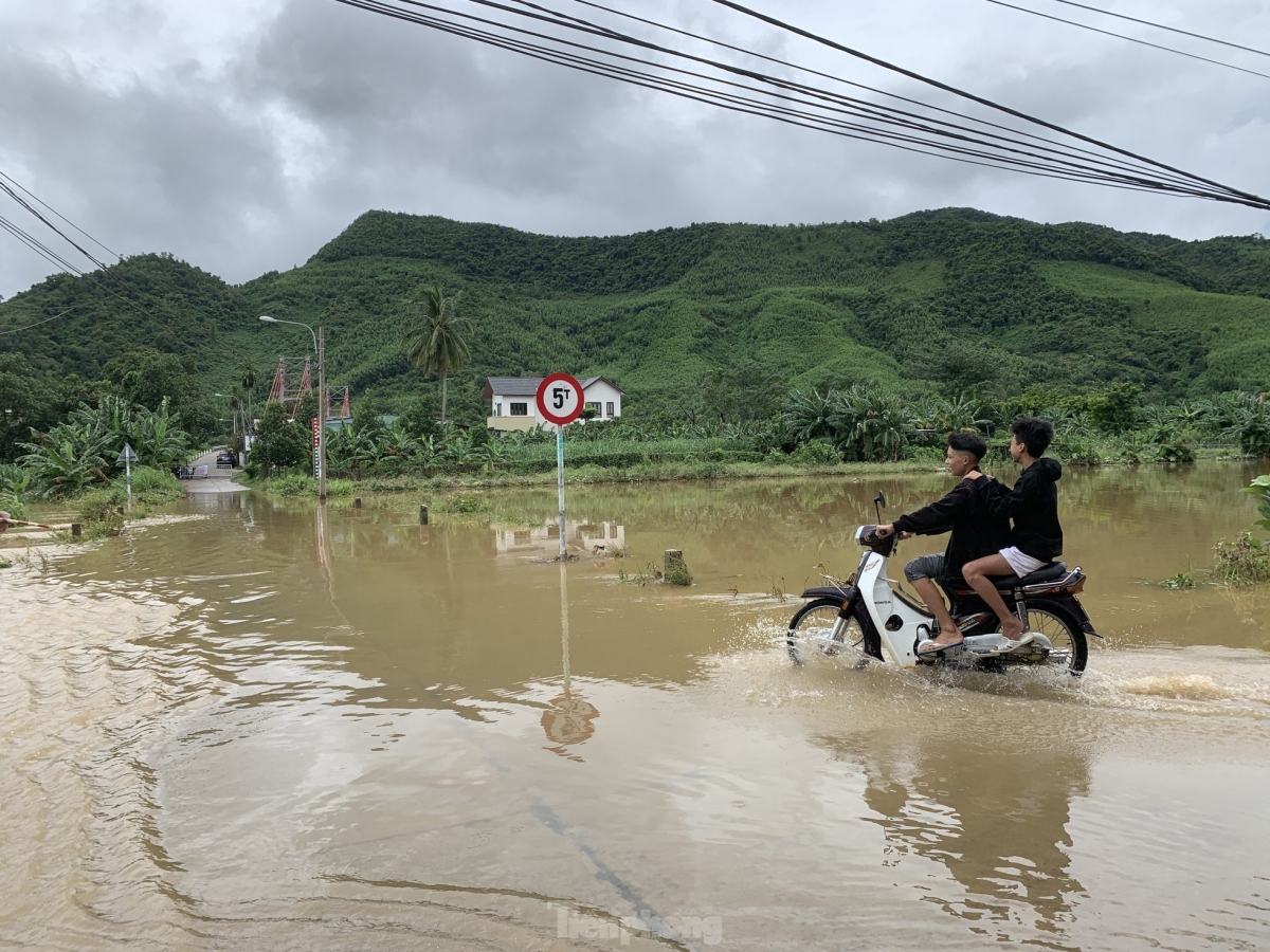 Motorcyclists are seen moving on a street in Hoa Vang district which is 30 to 40 cm under water.