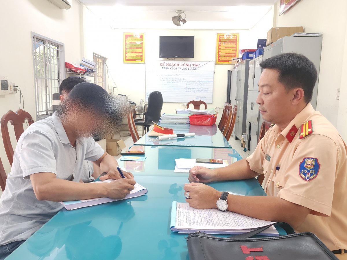 Tài xế điều khiển xe ngược chiều ký vào biên bản vi phạm
