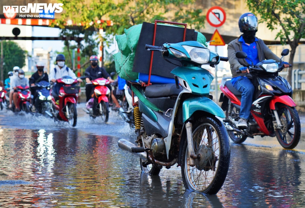A broken-down motorbike waits for rescuers on an inundated road.