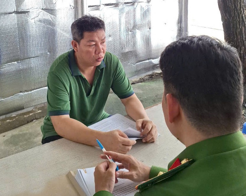 Cán bộ đang làm việc với bị can Nguyễn Quốc Tân tại cơ quan công an