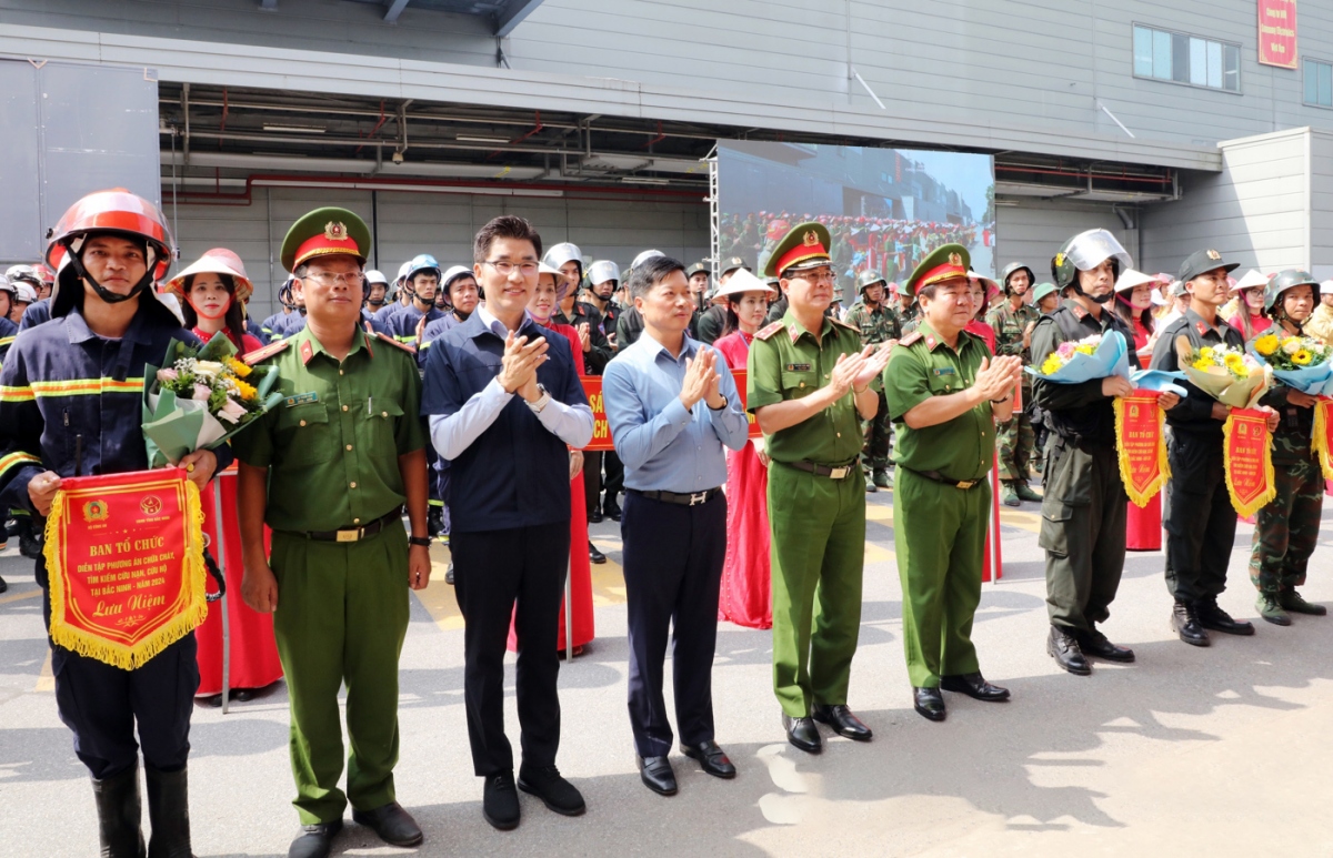 Phó Chủ tịch Thường trực UBND tỉnh Đào Quang Khải cùng các đại biểu lãnh đạo Cục Cảnh sát PCCC và CNCH trao cờ lưu niệm cho các lực lượng tham gia diễn tập