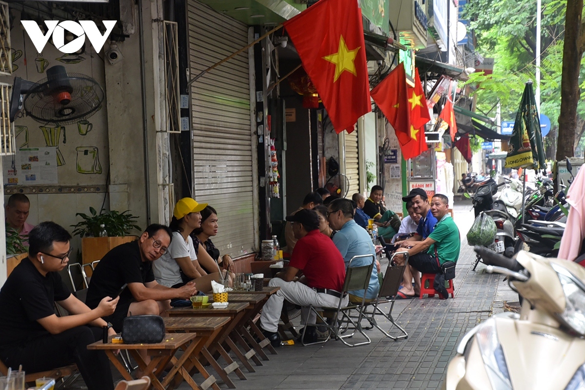 People enjoy the atmosphere of the national holiday whilst spending time at a café.