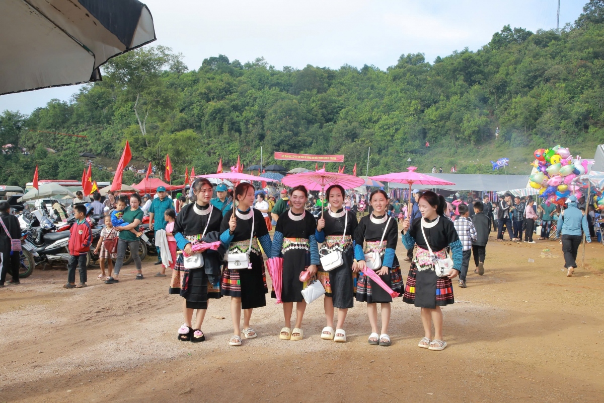 Từng tốp chàng trai, cô gái trong trang phục truyền thống đa sắc màu xúng xính xuống chợ.