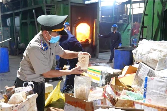 Chấp hành viên Cục Thi hành án dân sự TP.HCM cùng đại diện Viện Kiểm sát nhân dân Thành phố kiểm đếm tang vật trước khi đưa vào lò tiêu hủy (Ảnh: TTXVN)