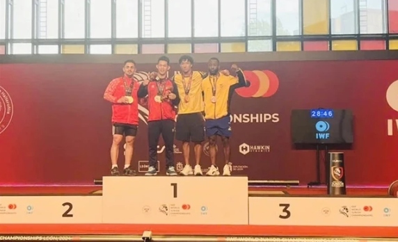 Tran Minh Tri of Vietnam (second left) takes two golds in the men's 67kg class at the World Youth Weightlifting Championships in Spain