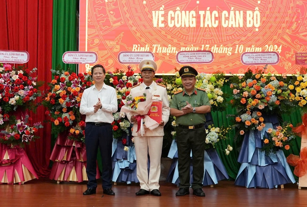 Chủ tịch UBND tỉnh Bình Thuận và Giám đốc Công an tỉnh tặng hoa chúc mừng Đại tá Nguyễn Anh Tuấn. Ảnh: CABT
