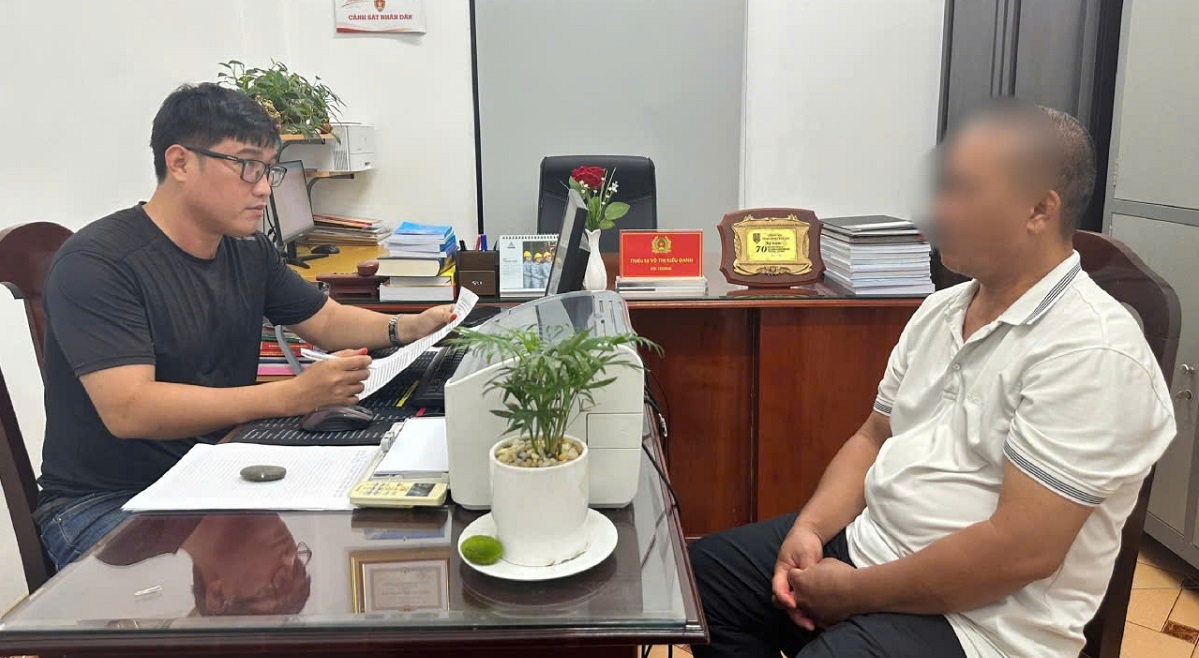 Cơ quan điều tra tiếp nhận đối tượng Nguyễn Văn Tốt (áo trắng) ra đầu thú.