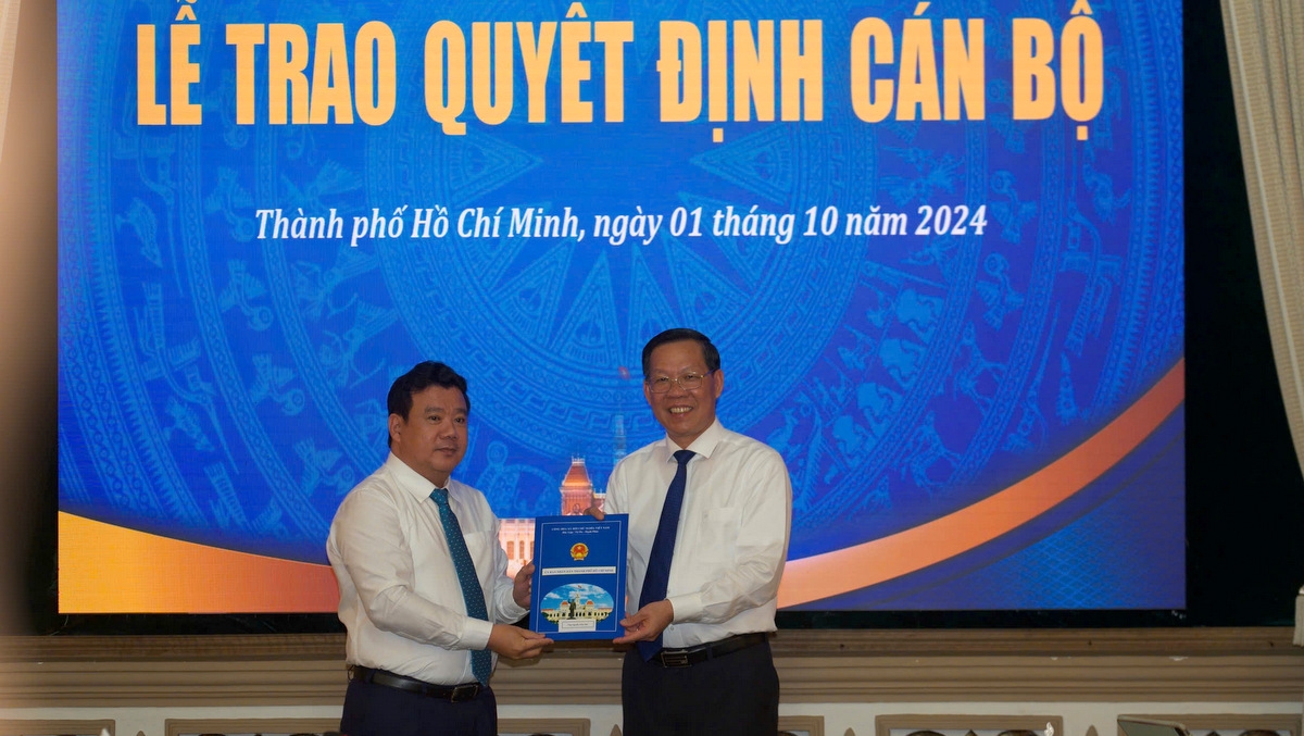 Ông Phan Văn Mãi trao quyết định cho ông Nguyễn Trần Phú làm Chủ tịch UBND quận Tân Phú (ảnh L.T)