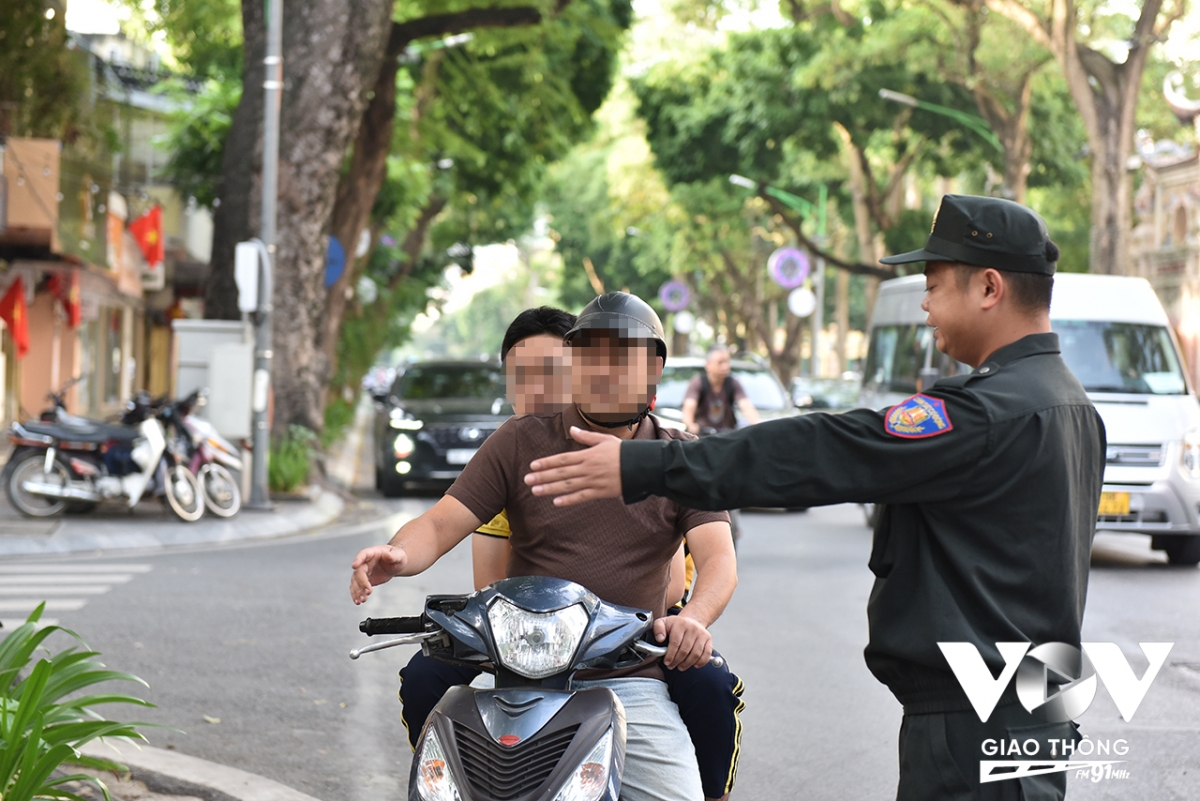Người đàn ông trong ảnh được lực lượng chức năng yêu cầu dừng xe để kiểm tra vì điều khiển phương tiện, chở theo người ngồi sau không đội mũ bảo hiểm.
