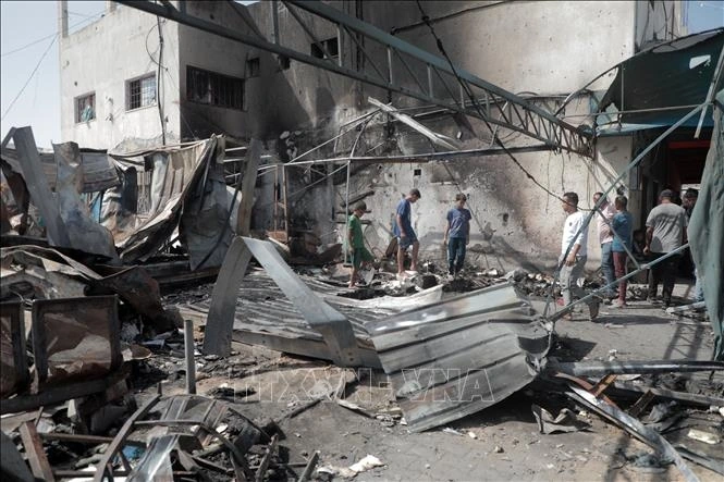 Hiện trường cuộc không kích của Israel xuống trại tị nạn ở thành phố Deir al-Balah, Dải Gaza. Ảnh: THX/TTXVN