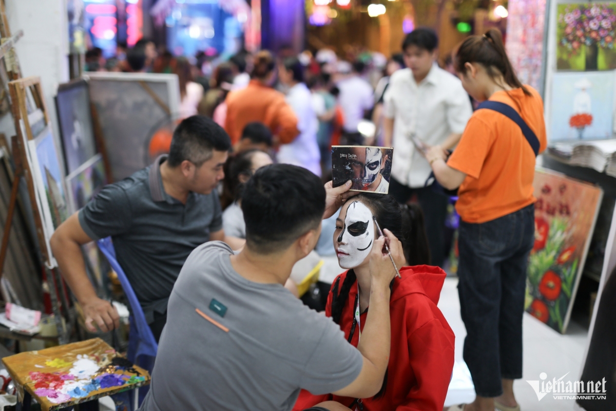 A girl has her face painted in the Halloween theme. Face painting services are offered from VND50,000 to VND100,000 per person.