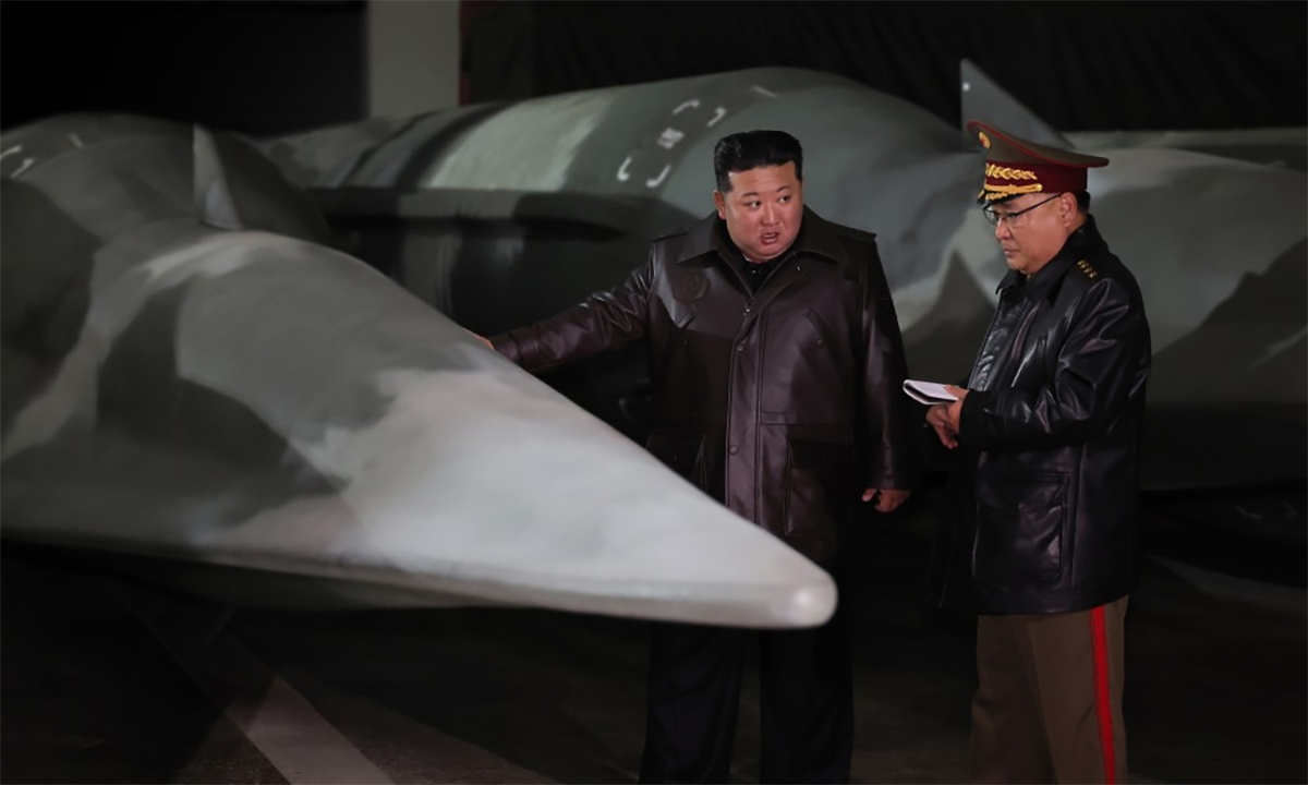 Lãnh đạo Triều Tiên Kim Jong-un đứng cạnh vật thể giống phương tiện lướt siêu thanh trên tên lửa Hwasong-8 trong ảnh công bố ngày 23/10. Ảnh: KCNA
