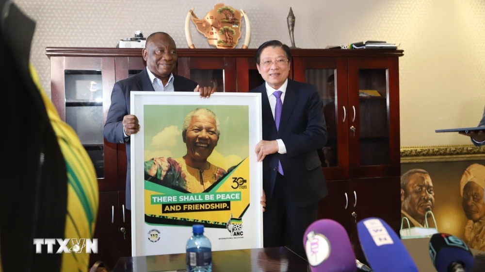 Chủ tịch đảng ANC, Tổng thống Nam Phi Cyril Ramaphosa (trái) tặng quà lưu niệm cho ông Phan Đình Trạc tại trụ sở đảng. Ảnh: TTXVN