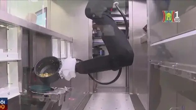 Cánh tay robot lấy nguyên liệu được chuẩn bị sẵn và đã chia theo khẩu phần, cho vào những chiếc nồi và nấu hoặc chiên trên bếp cảm ứng. (Ảnh: Hanoionline)