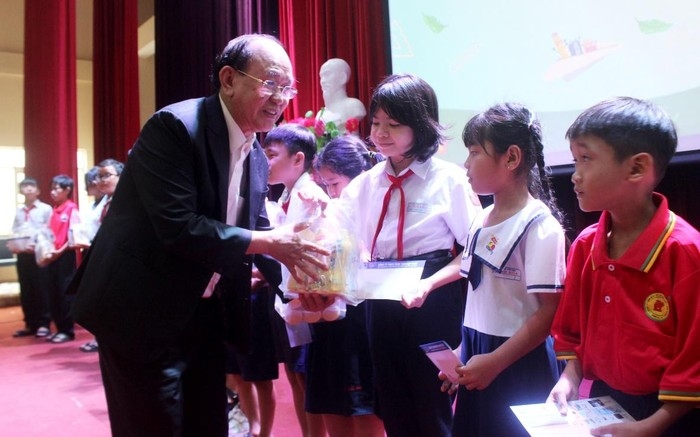 Ông Nguyễn Văn Tư trao tặng học bổng cho học sinh có hoàn cảnh khó khăn của tỉnh Bình Dương. Ảnh: Trần Khánh