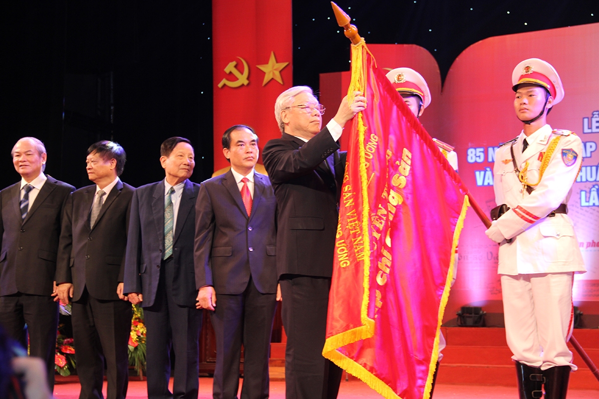 Tổng Bí thư Nguyễn Phú Trọng gắn Huân chương Hồ Chí Minh lần thứ hai lên lá cờ truyền thống của Tạp chí Cộng sản vào năm 2015. (Ảnh: Tư liệu TCCS)